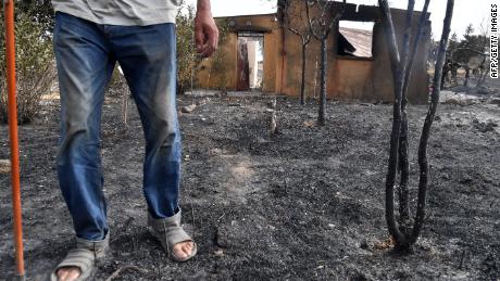 Un hombre camina frente a su casa después de que fuera destruida por un incendio forestal en la ciudad argelina de el-Kala, el 18 de agosto. Decenas de personas murieron y muchas más resultaron heridas el miércoles en los incendios forestales que asolaron las zonas montañosas de Argelia. este.  Las autoridades dijeron que 2.600 hectáreas fueron destruidas como resultado de las llamas.  