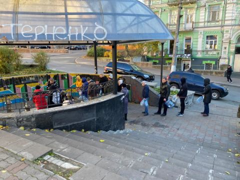 La gente hace fila con botellas de plástico en un centro de distribución de agua en el centro de Kyiv, después de que los ataques de Rusia dejaran cortes de agua en toda la ciudad.