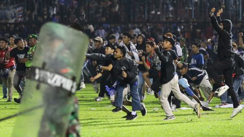 Los fanáticos del fútbol invaden la cancha en el Estadio Kanjuruhan en Malang, Java Oriental el sábado.