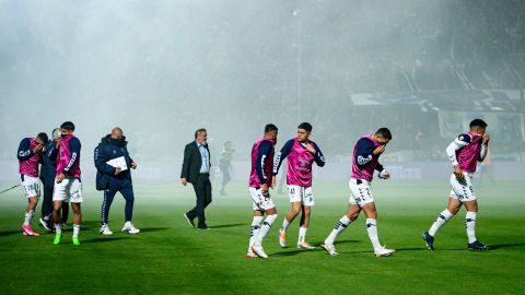 Los jugadores reaccionan tras verse afectados por gases lacrimógenos durante el partido.