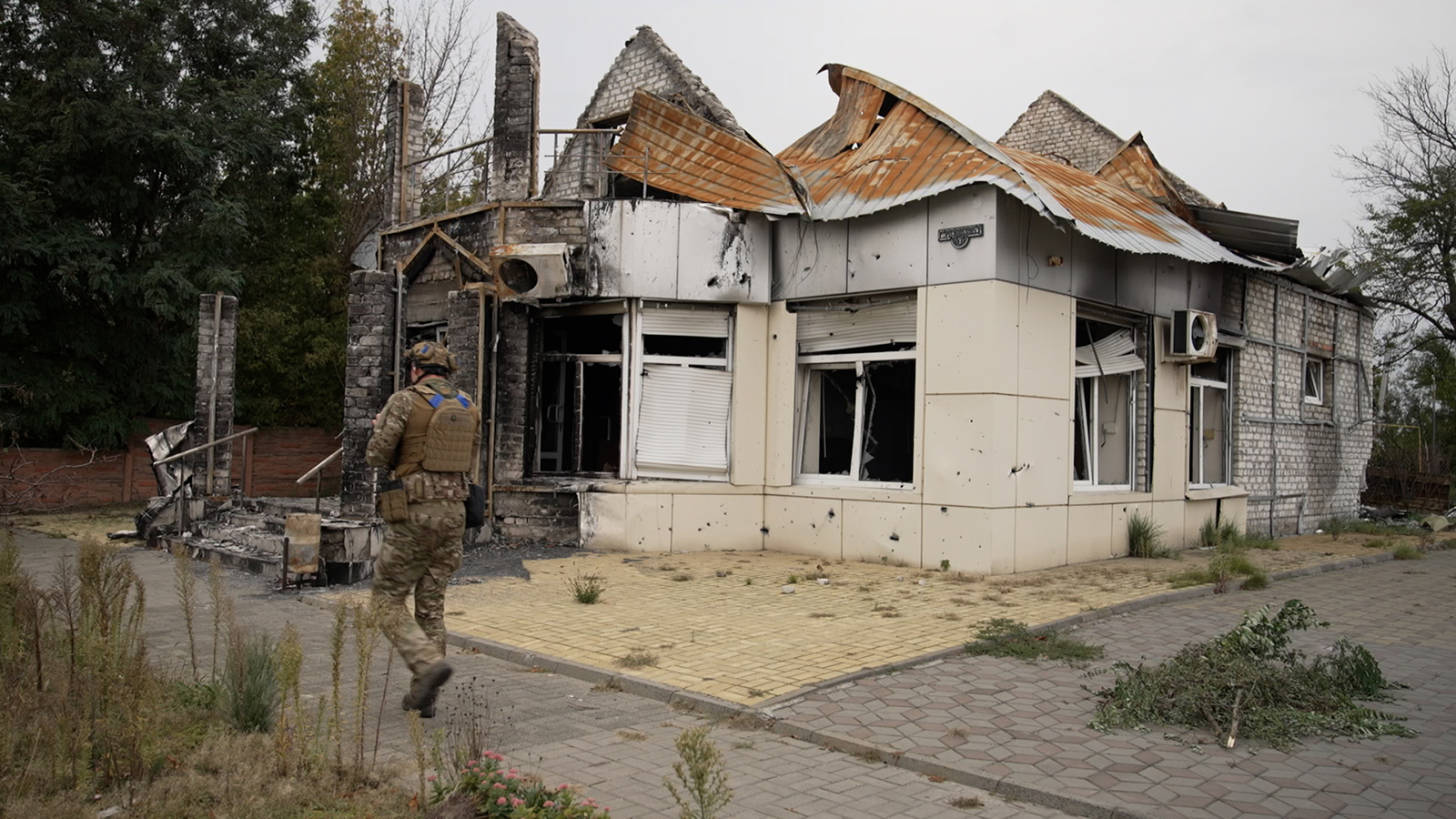 Un soldado ucraniano de la brigada Dnipro 1 pasa frente a un edificio dañado en el centro de Lyman, Ucrania, el domingo 3 de octubre de 2022.