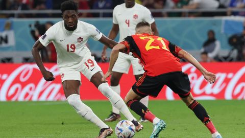 El delantero canadiense #19 Alphonso Davies lucha por el balón con el defensor belga Timothy Castagne.
