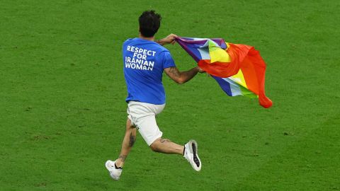 Un invasor de la cancha corre hacia la cancha con una camiseta con un mensaje que dice: