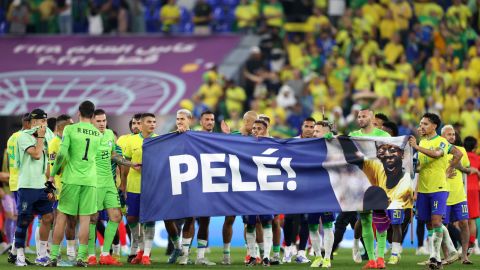 Los jugadores de Brasil sostienen una pancarta que muestra su apoyo a Pelé.