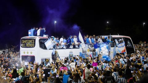 El equipo de fútbol de Argentina en un autobús en Buenos Aires el 20 de diciembre, rodeado de aficionados que vitoreaban.