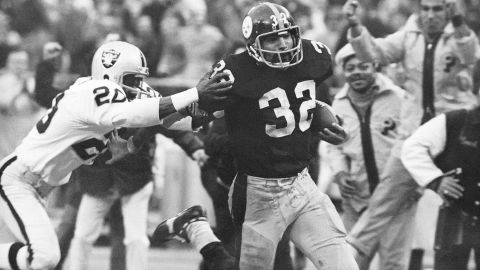 Harris (32) elude una entrada de Jimmy Warren de los Oakland Raiders mientras corre 42 yardas para un touchdown después de atrapar un pase desviado durante un partido de playoffs de fútbol americano de la División AFC de la NFL en Pittsburgh el 23 de diciembre de 1972.