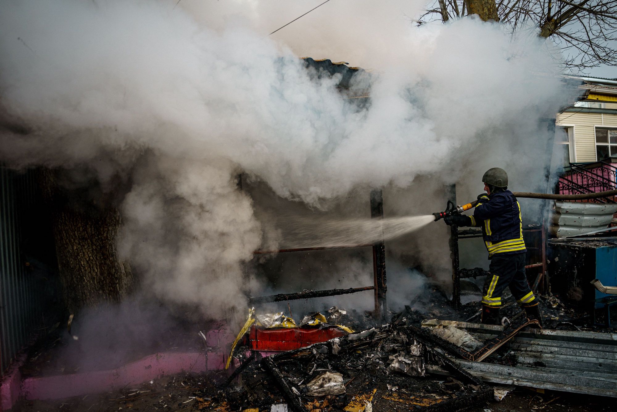 Un bombero apaga una tienda en llamas después de un bombardeo ruso en Kherson el 24 de diciembre.