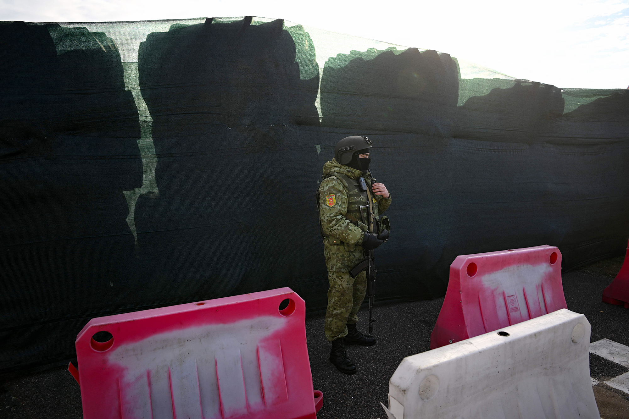 Un guardia fronterizo bielorruso vigila junto a una barricada hecha con neumáticos de camiones en el cruce fronterizo de Dyvin entre Bielorrusia y Ucrania en la región de Brest el 15 de febrero.